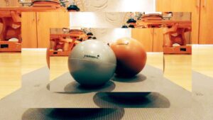 Two balls are sitting on a table in front of some lights.